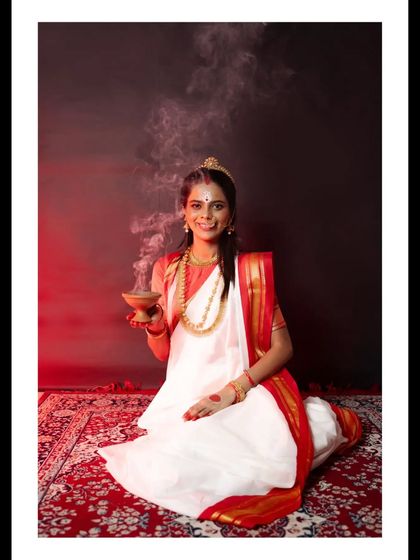 A smiling portrait of a woman dressed for Durga Puja, holding a traditional clay incense burner. This shot captures the devotion and happiness associated with the festival, celebrating the spirit of Pujo.