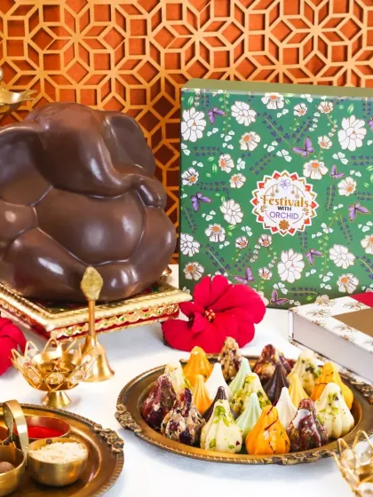 A beautiful Ganesh Chaturthi hamper with a chocolate Ganesha and a platter of assorted premium modaks. The elegant packaging and festive props make it an ideal corporate or personal gift.