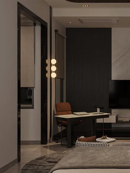 A small, functional workspace is carved out in the corner of the bedroom, featuring a minimalist desk and a modern pendant light. The dark, fluted wall panel adds texture and depth.