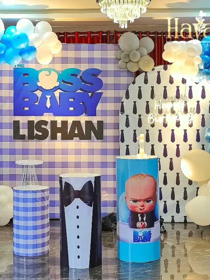 A grand Boss Baby setup with multiple backdrops, including a tie-pattern print. The blue, grey, and white balloon arrangement adds a sophisticated yet fun touch.