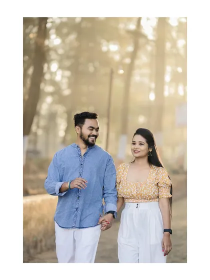 The golden morning light hitting this couple as they walk along a path near the beach creates a warm and happy feeling.