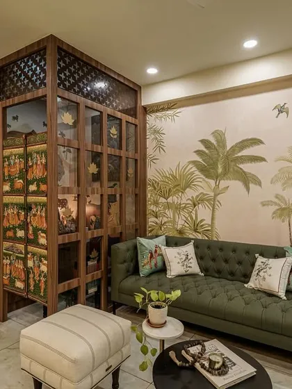 A living area with a cozy swing seat, hand-painted puja doors, and lush greenery.