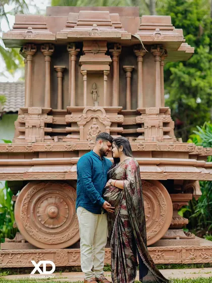 A romantic pose in front of a magnificent temple chariot replica. This unique backdrop adds a touch of grandeur and cultural significance to your maternity photoshoot.