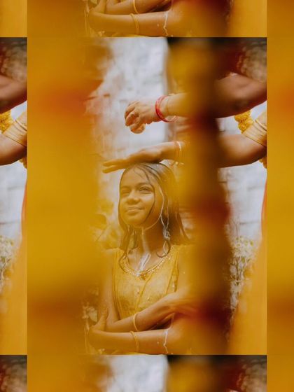 An artistic shot of a young woman during her Mangala Snaanam, viewed through a curtain of yellow flowers.
