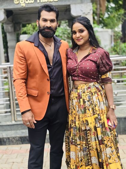 A full-length photo of the 'Raja Rani' couple. Her skirt has a unique print, and his blazer adds a pop of colour. I love creating these coordinated looks.