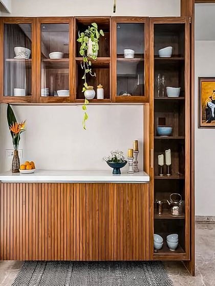 A beautiful wooden crockery unit with fluted lower cabinets and glass-fronted upper cabinets. This piece combines modern design with natural textures, providing elegant storage for your dining essentials.