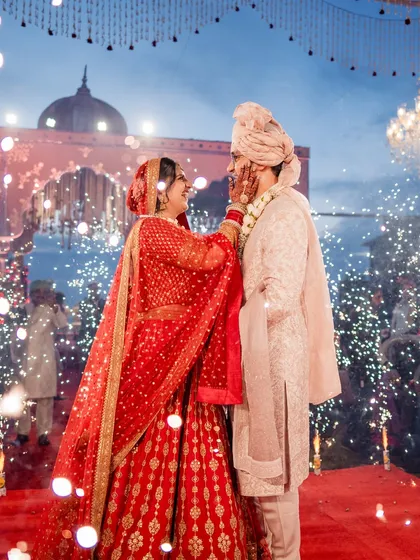 A beautiful, romantic portrait of the couple during their varmala ceremony, enhanced with a Ghibli-style artistic filter.
