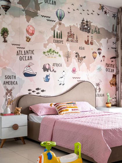 Adventure awaits in this child's bedroom, featuring a large, illustrated world map wallpaper. The soft pink and neutral tones create a sweet and calming atmosphere, perfect for dreaming of faraway places.