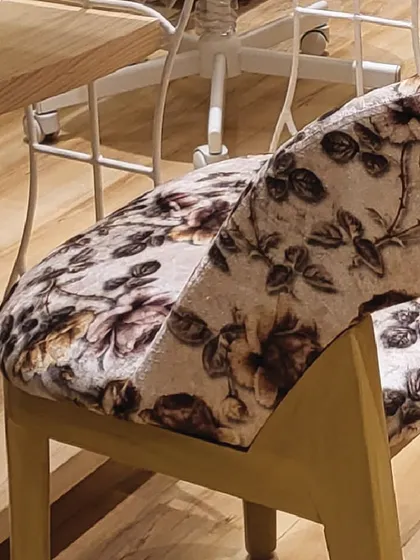 A close-up of our custom-designed chairs. The soft floral fabric and modern wood finish are part of the comfortable and photo-ready environment I've created for you.