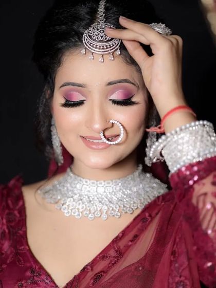 A model wearing a maroon saree with a delicate American Diamond choker and maang tikka. This is a perfect look for a Karwa Chauth or engagement function.
