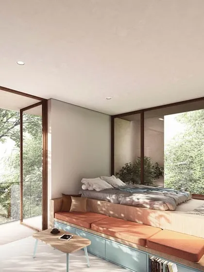 This compact studio apartment in 'The Nest' is designed for modularity and efficiency. The bed is elevated on a built-in platform that incorporates seating and storage, maximizing functionality while maintaining an open, airy feel with large windows.