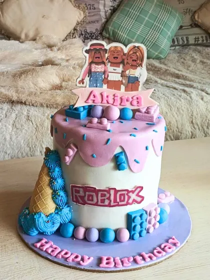 A fun and trendy Roblox-themed cake with a pink drip effect, game-inspired blocks, and a custom character topper for a stylish gamer's birthday.
