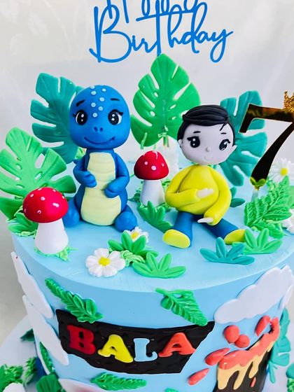 A detailed shot of the top of the dinosaur cake, with the boy and a blue T-rex.