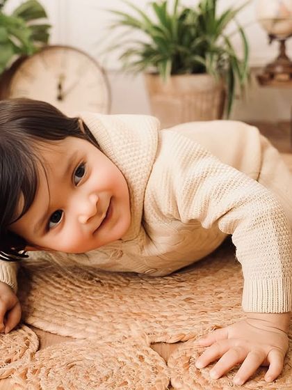 A sweet moment of exploration on the floor, as the one-year-old crawls across the jute rug, smiling back at the camera.
