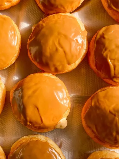 A tray of my Biscoff-filled doughnuts, topped with a smooth Biscoff glaze. The caramelized cookie flavor is a perfect match for the soft brioche.
