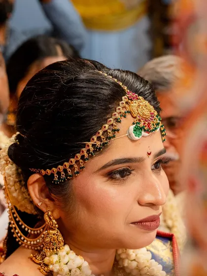 A close-up of this bride's traditional look, focusing on the intricate matha patti and her defined eyes.
