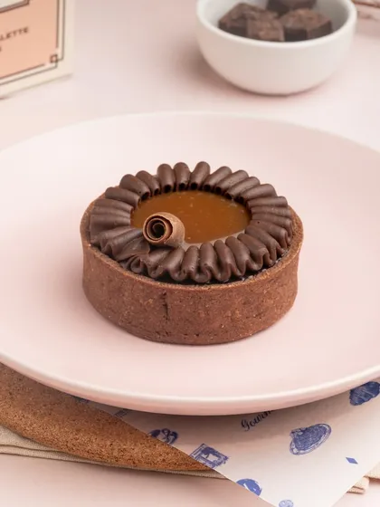 The rich, dark filling of my Sea Salt Caramel Tart, surrounded by a piped border of chocolate cream.