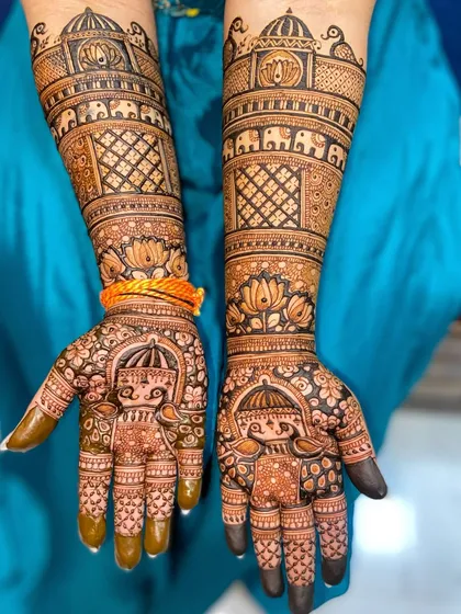 This design showcases royal Rajasthani motifs, including palace architecture (jharokhas), marching elephants, and a bride in a doli (palanquin) on the palms.