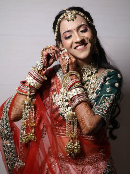 A candid moment with one of our happy brides. She is wearing a full rental set complete with a choker, matha patti, nath, and hathphool, showing how our jewellery completes the bridal transformation.