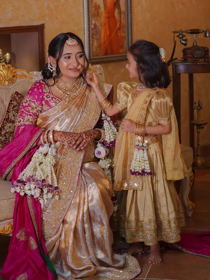 A playful moment where the daughter adjusts her mother's floral hair accessory.