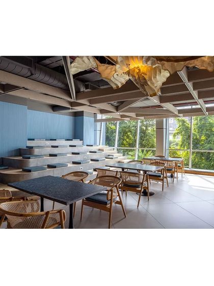 The amphitheater-style seating at the Paras Healthcare office provides a flexible space for presentations, informal meetings, or individual work. The large windows flood the area with natural light, promoting a sense of well-being.