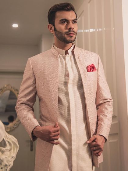 A beautiful pink jacquard Bandhgala jacket, perfect for a daytime wedding or festive event. This piece is a testament to the elegance of pastel-themed celebrations.