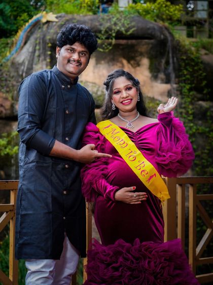 A joyful portrait with the couple proudly wearing "Mom to be" and "Dad to be" sashes. This outdoor shot captures their excitement and readiness for parenthood.