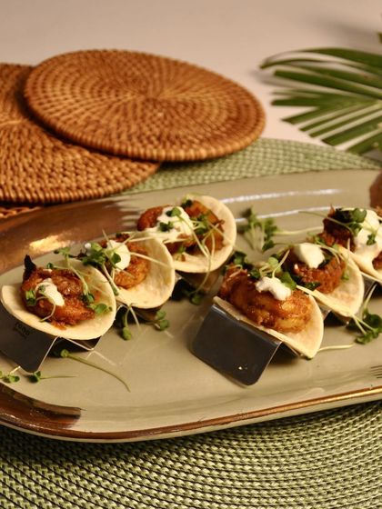 These are my Prawn Sukha Tacos, another coastal Indian fusion dish. The dry-spiced prawns are packed with flavor and served with a cooling topping in a mini taco shell.