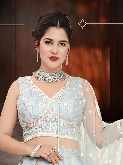 A close-up of the sky blue lehenga, highlighting the delicate embroidery on the blouse and the elegant diamond necklace it pairs with.