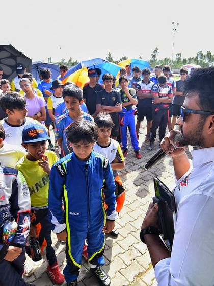 A race official addresses the young drivers during a briefing, emphasizing the importance of sportsmanship and safety.