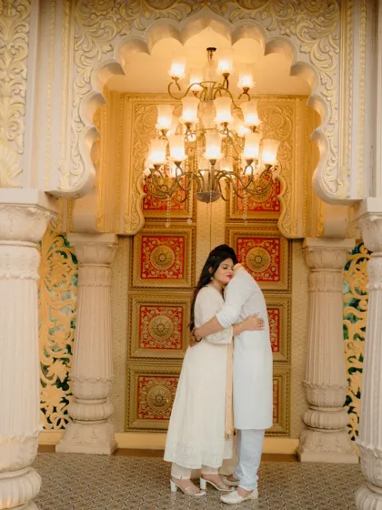 A quiet embrace in a royal setting. This shot captures the luxury and intimacy of a destination pre-wedding shoot, with the grandeur of the palace architecture framing a deeply personal moment.