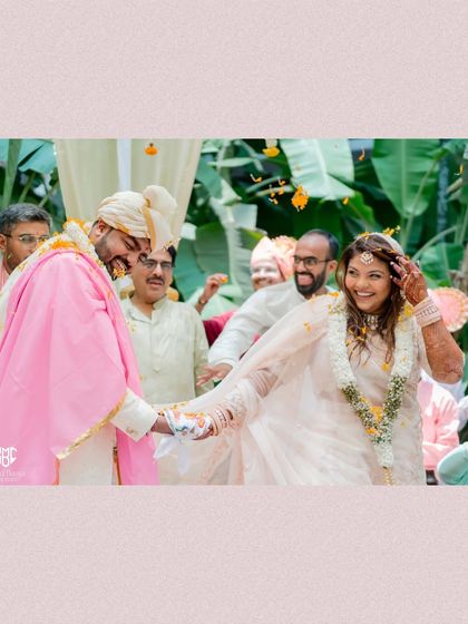 A candid moment of laughter and joy as the couple participates in their Gujarati wedding rituals, surrounded by family.
