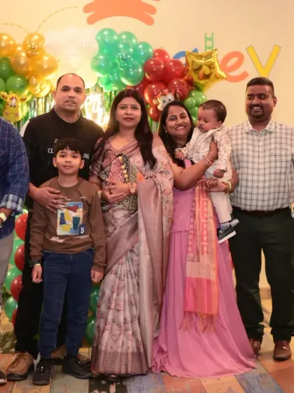 A large family group photo, capturing three generations celebrating together.