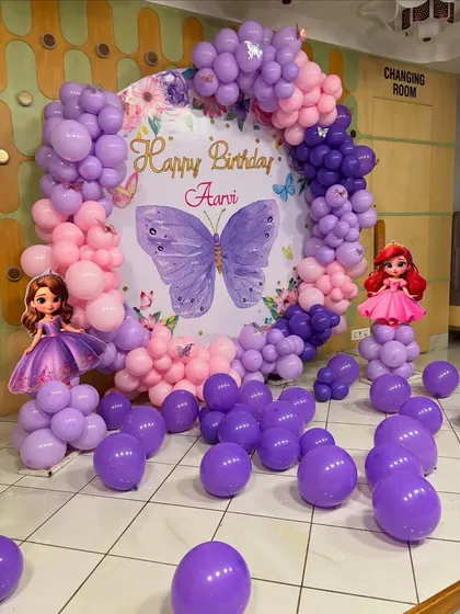 The full setup for the butterfly theme party, showing the main backdrop flanked by princess and butterfly props.