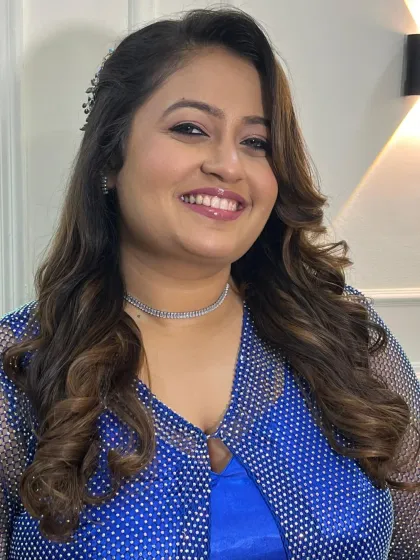 A happy and smiling portrait of the client, her makeup looking fresh and glamorous.