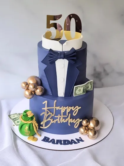 Cheers to 50! This two-tier tuxedo cake in a striking navy blue is perfect for a milestone birthday, complete with a bow tie and a bag of money.
