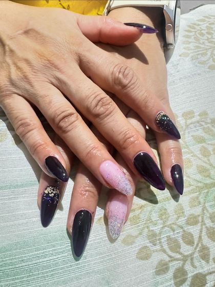 A dark and glamorous set with deep purple nails, accented with a pink and silver glitter ombre.