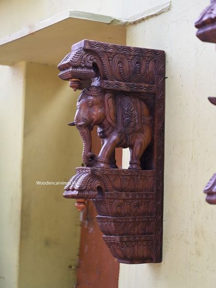A side view of the 24-inch elephant bracket. This angle highlights the depth of the carving and the three-dimensional form of the elephant, which appears to be stepping out from the wall.