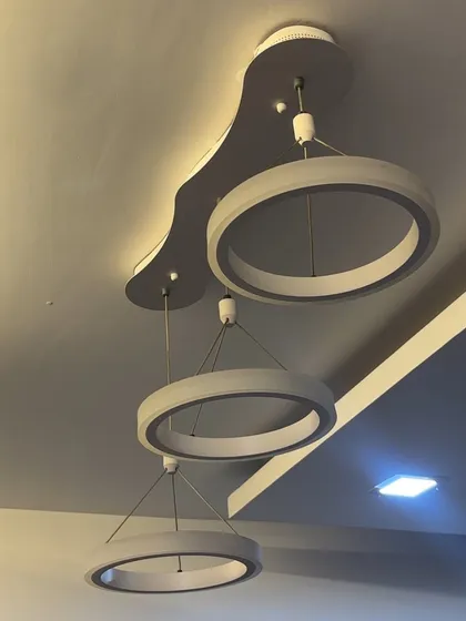 Installation of a contemporary three-ring LED pendant light. This type of modern chandelier is perfect for living rooms or dining areas, and I ensure it's hung securely and wired correctly for optimal performance.