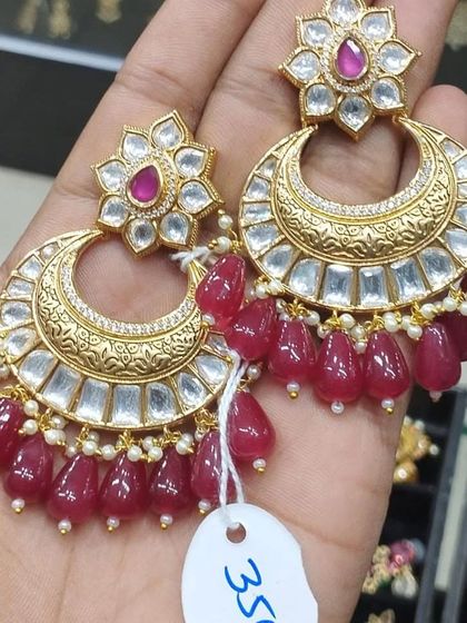 A beautiful pair of chandbali earrings with kundan work and ruby-colored bead drops.