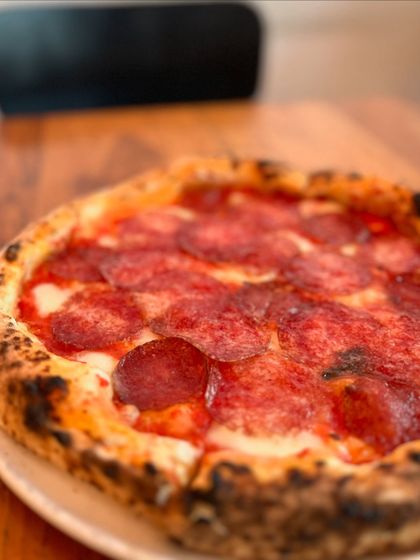 A close-up of the Hungarian Salami pizza, showing the beautiful texture of the cured meat.