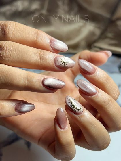 This set features a beautiful neutral-toned cat eye effect with unique accent nails. One nail has a delicate star charm, while the other features a 3D evil eye design for a touch of personality.
