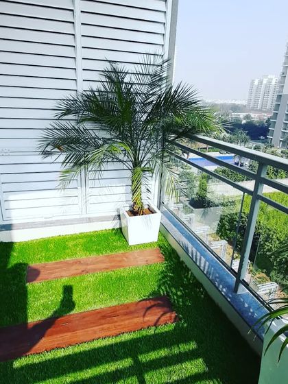 The same Gurgaon balcony, showing the combination of artificial grass and wooden plank flooring for a stylish look.