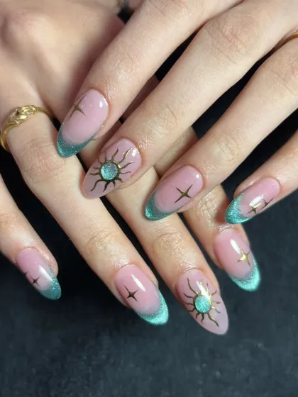 An enchanting design with a teal cat eye French tip and delicate sun and star illustrations.