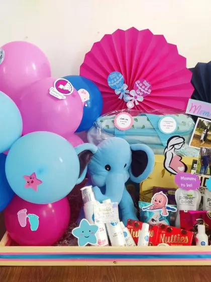 Pink or blue, what will it be? This hamper is perfect for a gender reveal party, featuring a plush elephant, baby essentials, and a mix of pink and blue balloons.