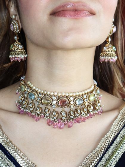 If you love statement pieces, this 9-gemstone jewel is for you. This Navratan choker is paired with matching jhumkas for a touch of tradition.