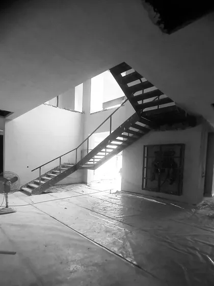 Another angle of the lounge under construction, showing the basic structure of the staircase and the natural light filtering in.