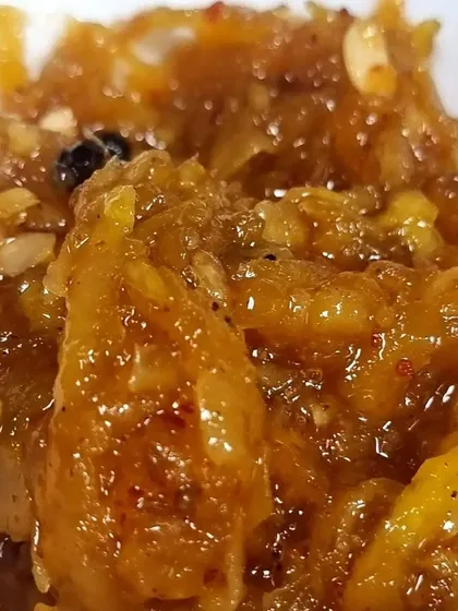 A close-up of the texture of my Aam ki Chutney. You can see the grated mango shreds and whole spices. It's a chunky, flavourful chutney that is perfect with roti or bread.