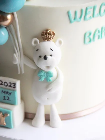A close-up of the adorable, handcrafted polar bear topper wearing a tiny crown.
