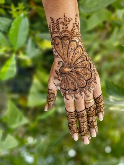 A close-up of the peacock motif on the back of the hand. I love creating these graceful birds as they are a timeless symbol in Indian mehendi art.